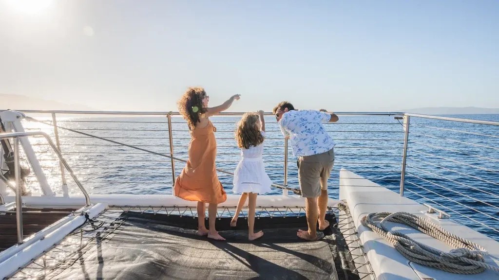 Family on a boat enjoying the ocean view on a sunny day.