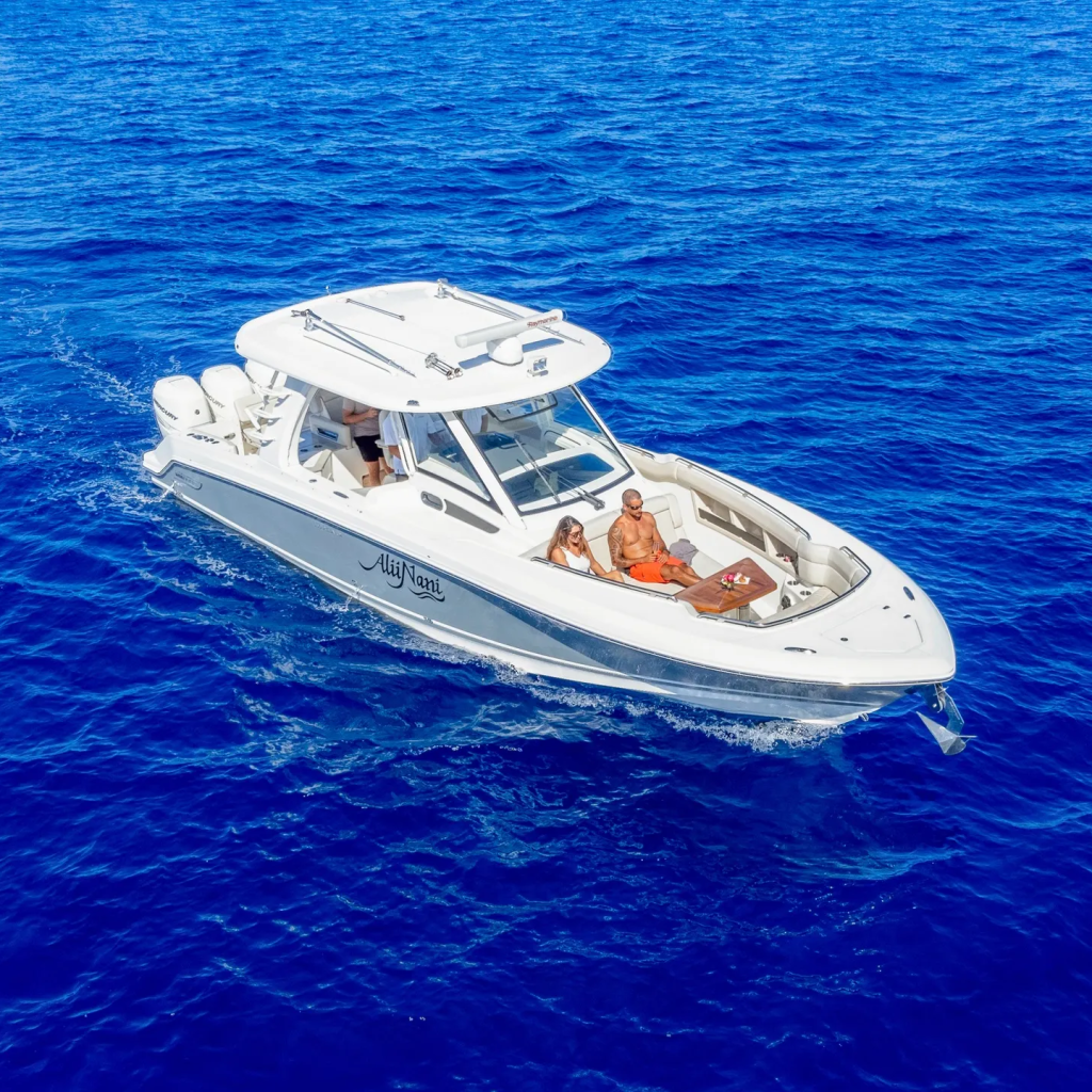 White motorboat with people cruising on clear blue ocean.